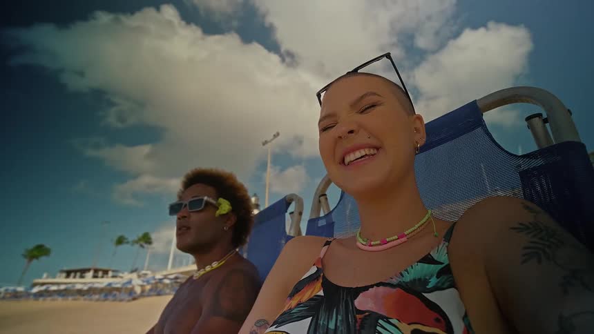 Woman and a man sitting on a chair on the beach