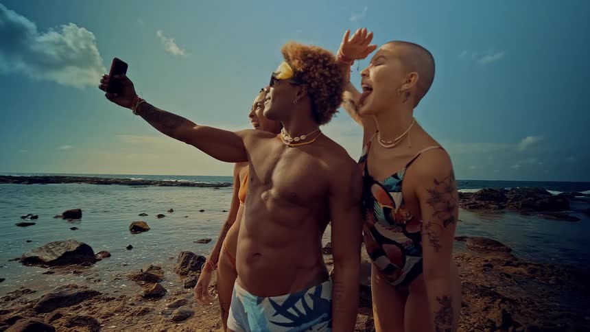 Group of friends takes a selfie while enjoying time at a rocky beach