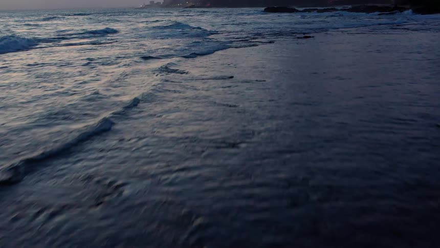 Panning over the ocean before angling up to a city skyline