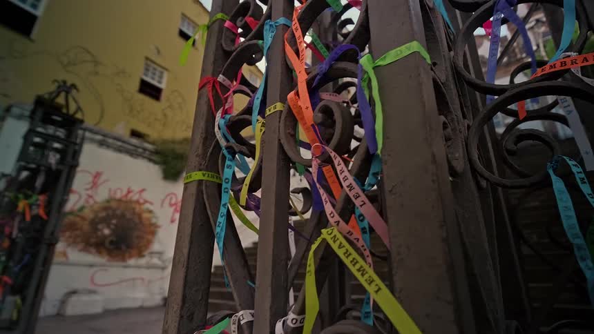 Colorful religious ribbons tied to a metal gate