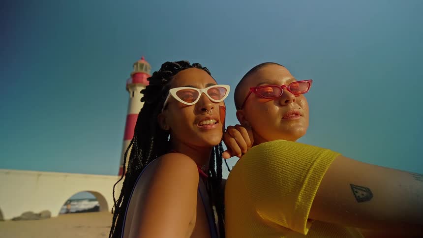 Close up portrait of two female adult friends outdoors at the beach during daytime