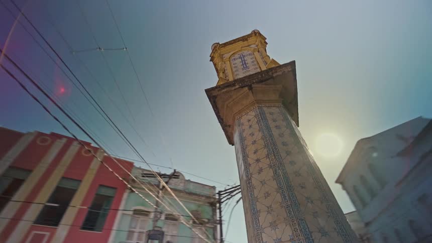 Monument in a public square surrounded by classical buildings of different colors