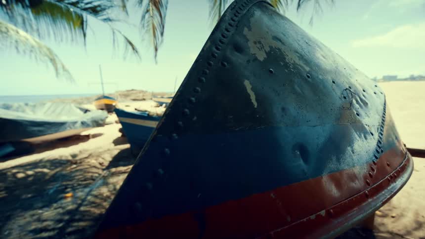 A canoe turned upside down on the shore with other canoes docked on the beach