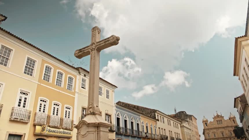 Monument of a cross in a square with classical buildings around