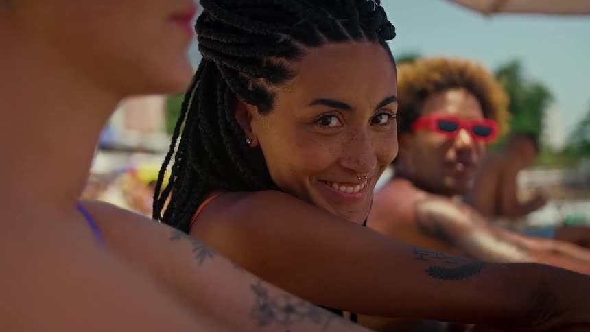 Woman smiling while sitting with her friends in a beach setting