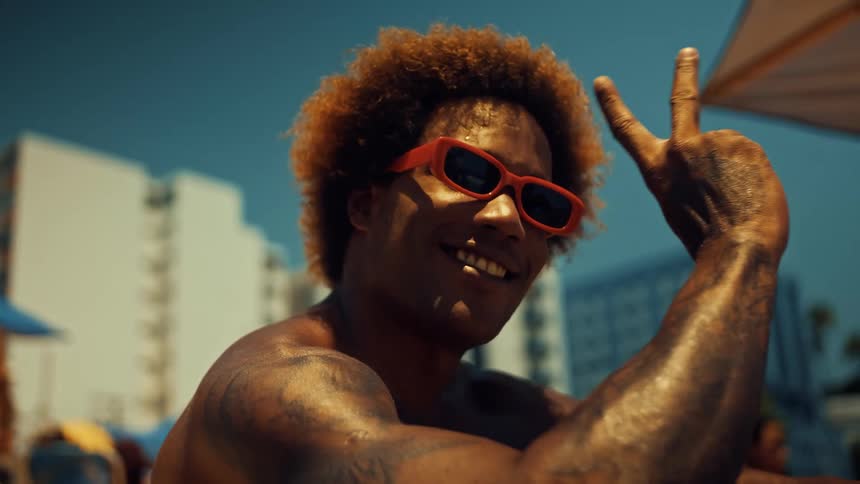 Close up portrait of a young black man displaying the peace sign while outdoors during daytime