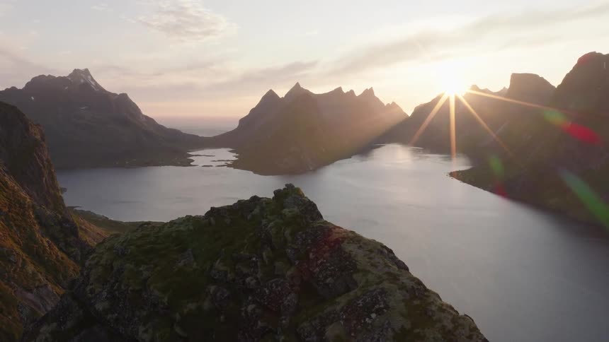 Aerial pornography tame surrounded by ruins and mountains as the sun rises on the horizon