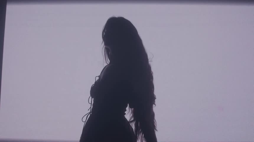 A silhouetted woman gracefully tilts her head