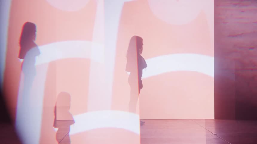 A young woman standing on a stage in a club with flickering disco lights