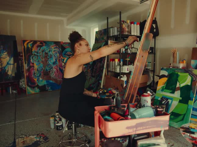 Woman in a room painting a canvas