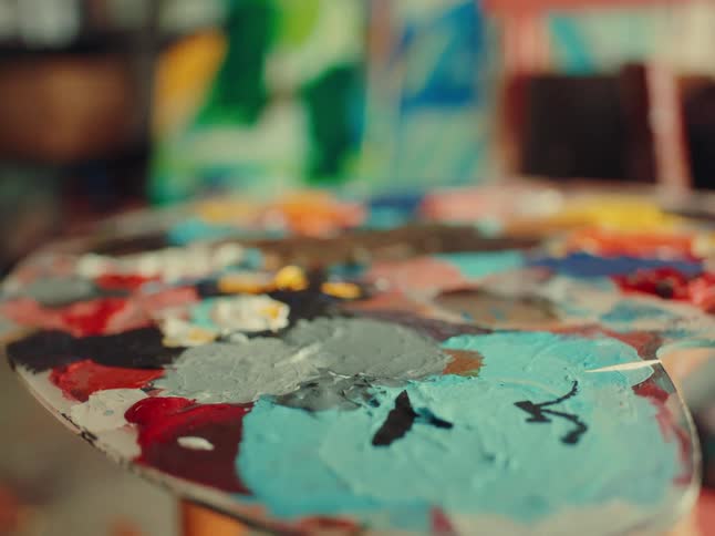 Close up of a paint palette with different colours on a stool in an art shop