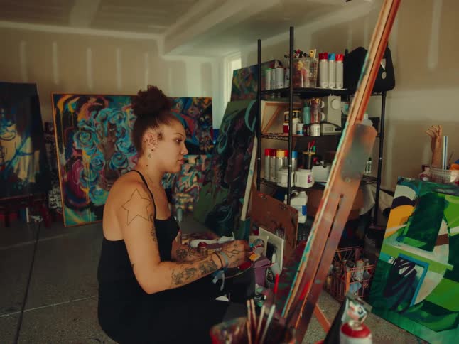 A woman paints on a canvas in an art studio