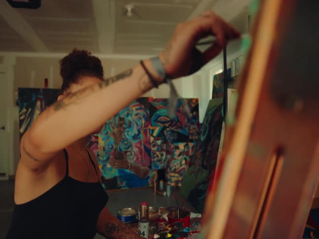 Woman painting a canvas in an interior space
