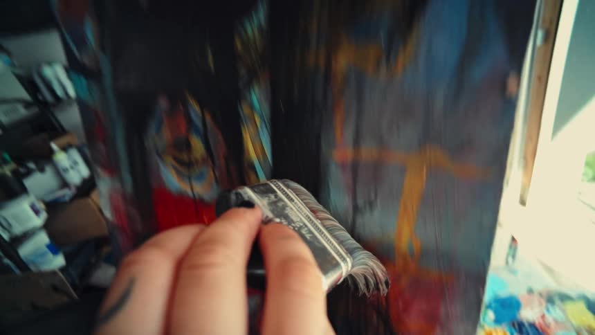 Close up of a person painting on a canvas in an art shop during daytime