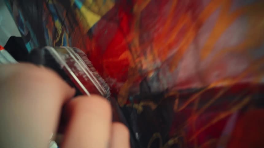Person with a paintbrush painting a canvas