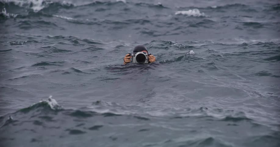 Filmmaker with a professional camera in the sea