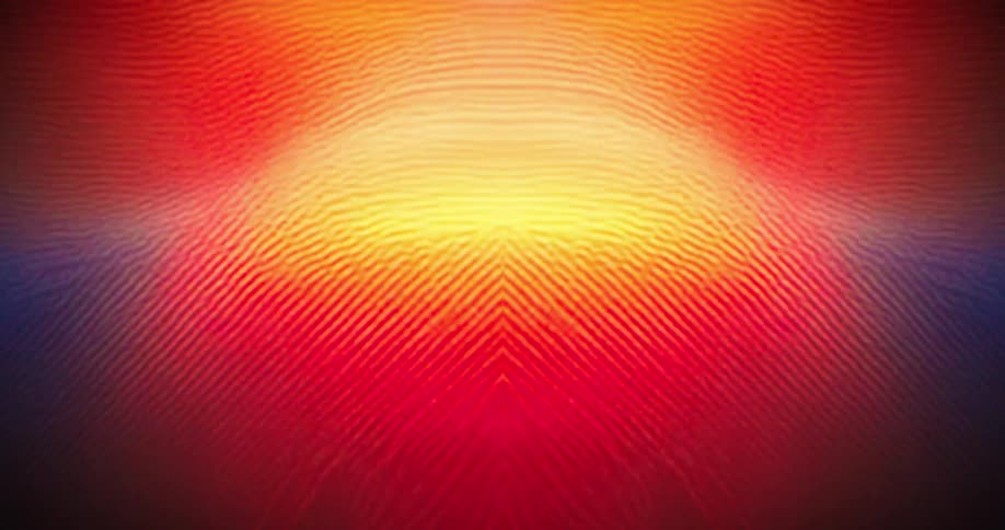 A symmetrical abstract pattern of light and colors pulses and shifts changing from hues of blue and green to bright orange and purple