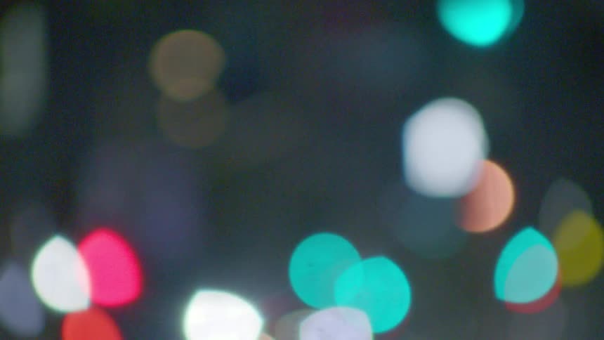 Vibrant outoffocus city lights form soft colorful bokeh against a dark nighttime backdrop