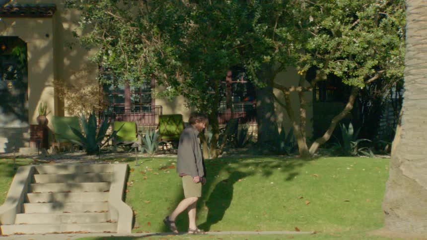 The man is walking through the neighborhood