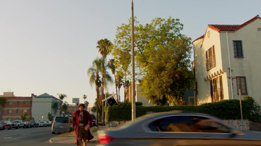 Man wearing a long coat crosses the street
