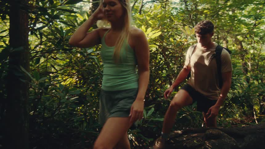 Woman and a man hiking through a forest