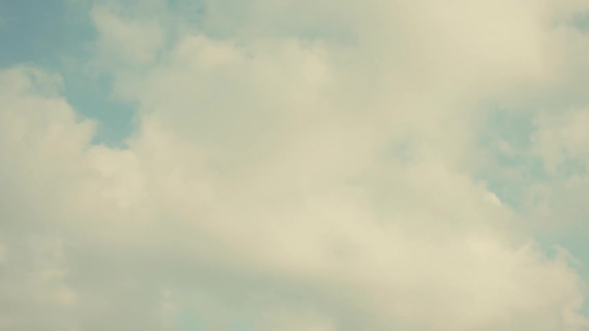 Soft clouds drift across a pale blue sky