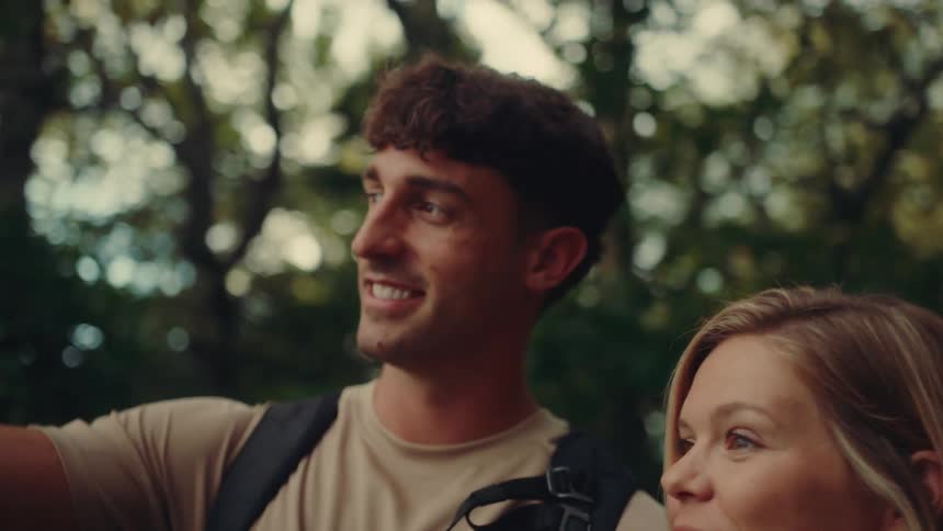 Woman and a man talking and smiling while walking through a natural area
