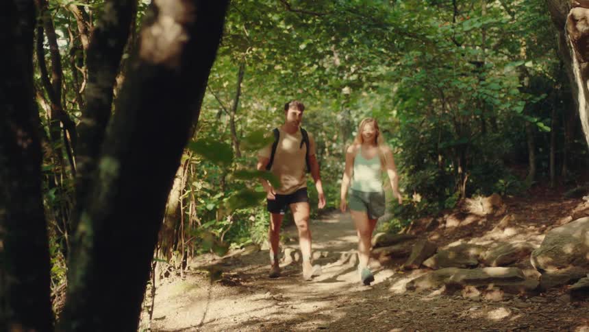 Blonde woman and a man hiking through the forest