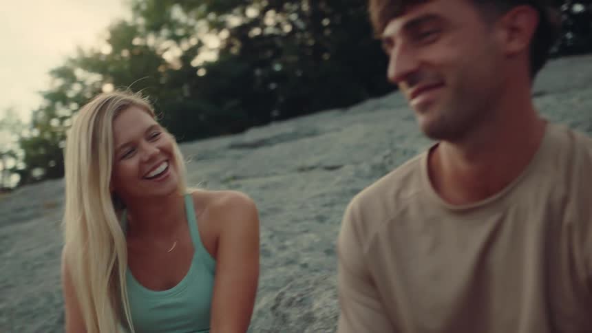 Smiling woman talks with man sitting outdoors