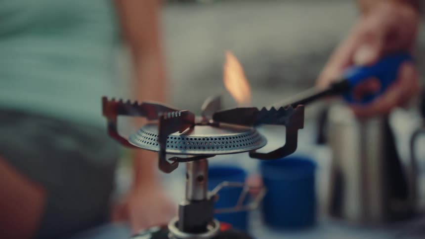 Person lighting a portable stove