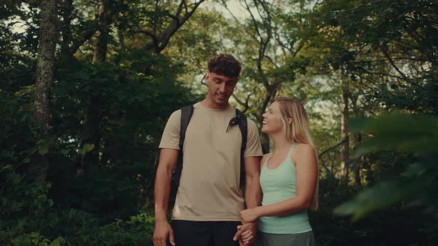 A couple of hikers are talking while on a path through the woods