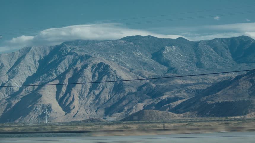 A transportation truck drives on the road by the mountain