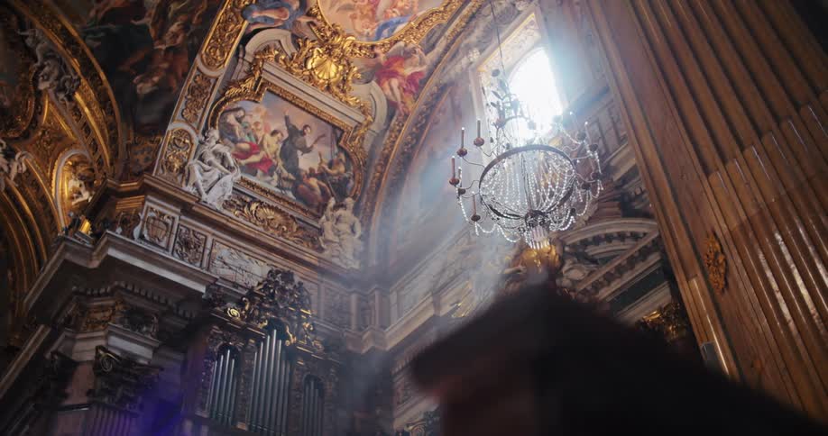 Paintings framed in ornate woodwork on the ceiling of a church