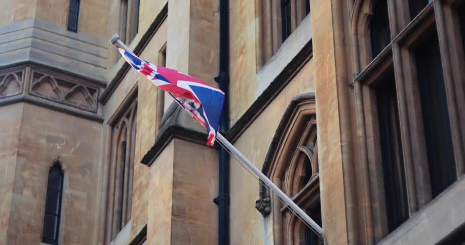 The wind is blowing the flag on the building