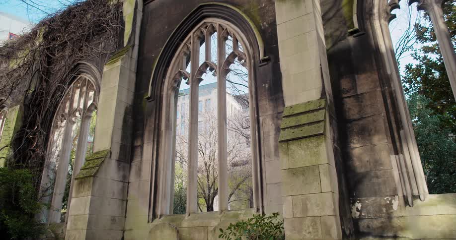 The ruins of st dunstanintheeast church garden with grass growing on the building walls and no roof at midday