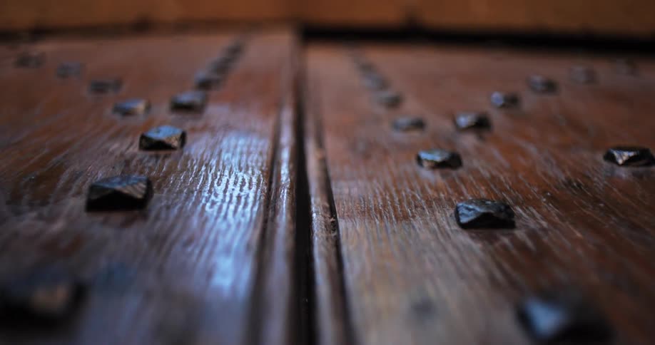 Closeup of an old wooden door with protruding metal studs