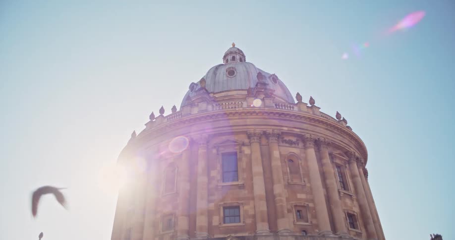 Upward view of a classic dome against a cloudless blue sky