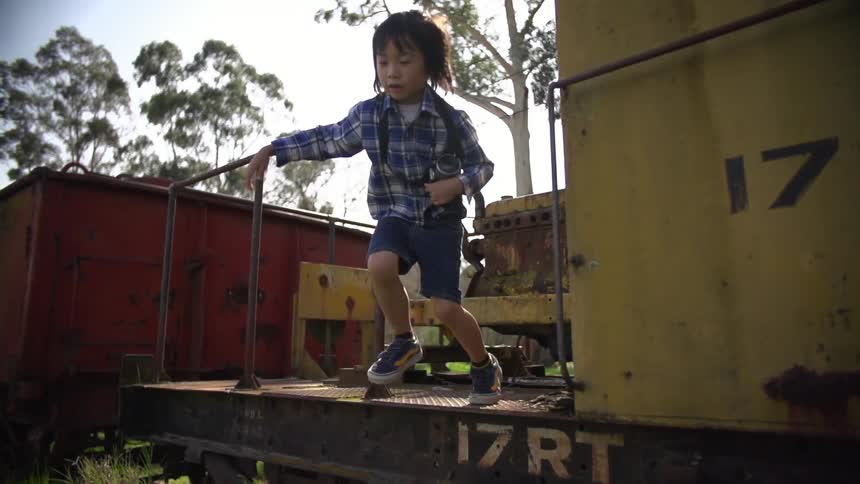A boy jumping off of a train