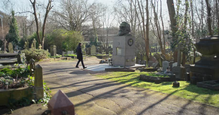 A man walking inside a cemetery at midday