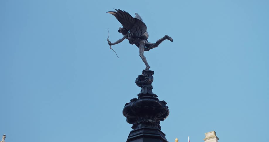 An angel statue at the top of a building outdoors during daytime