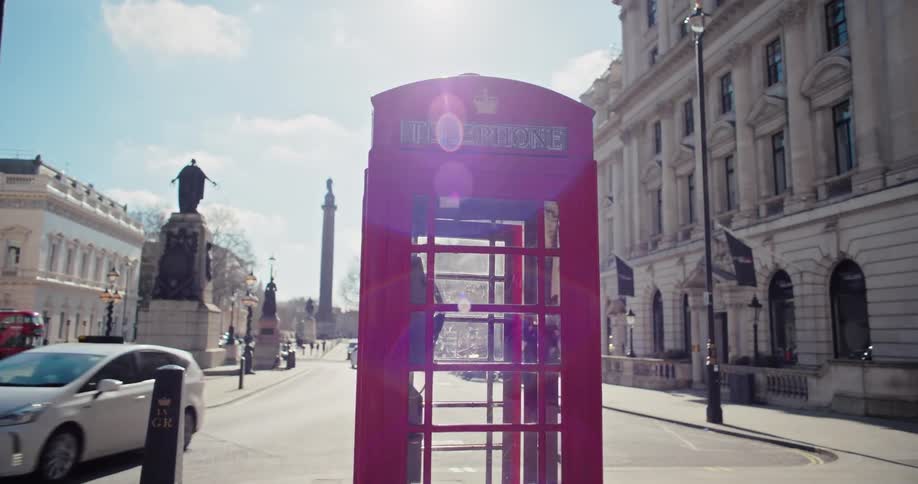 Red telephone booth in the middle of a city square