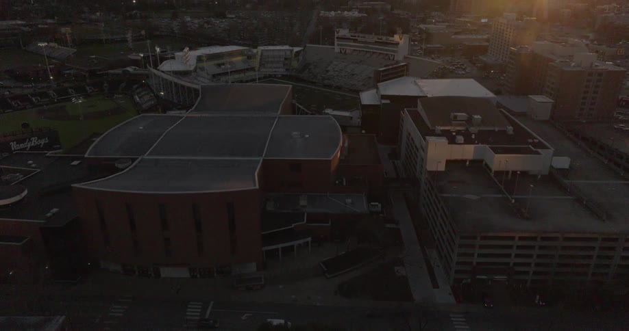 Aerial view of a stadium and urban buildings at sunset