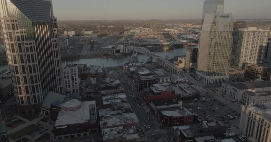 Urban aerial view at sunset with tall buildings and a bridge over the river in the background