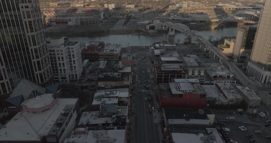 Aerial view of a busy avenue in nashville with the cumberland river and bridges in the background