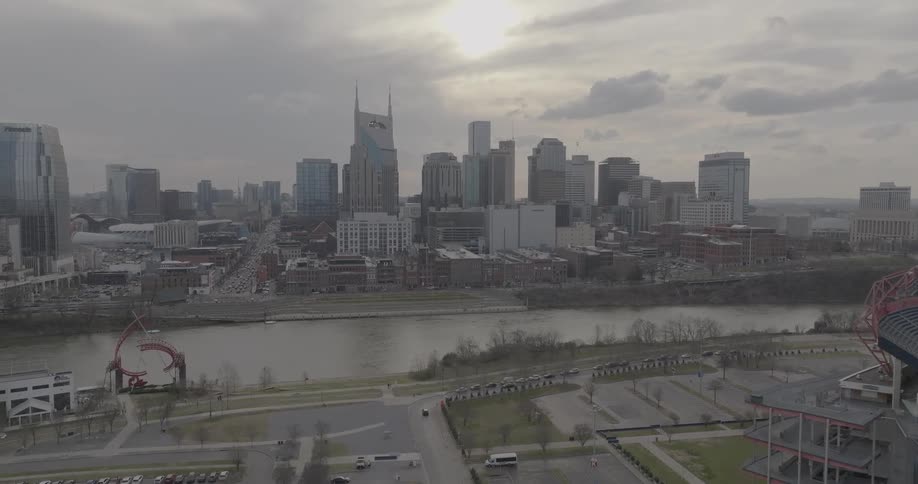 An aerial view of nashville at twilight highlights the glowing bridgestone arena the att building and scattered foot traffic below