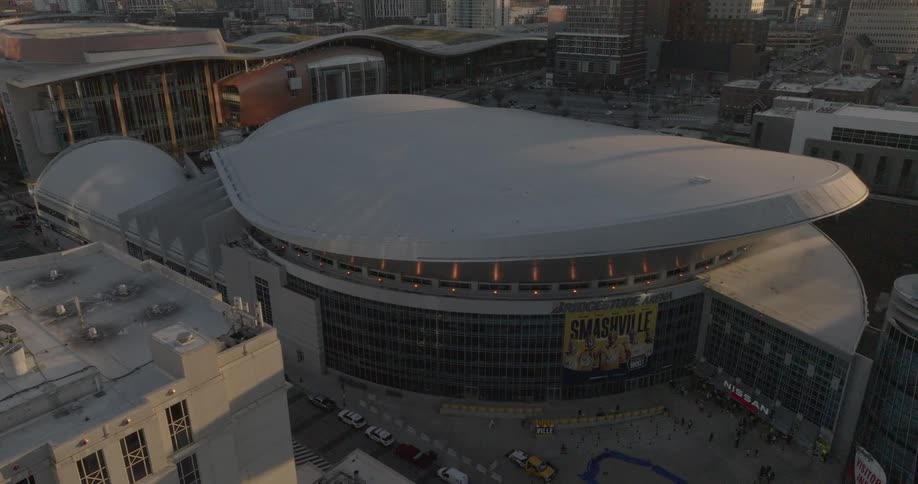 Bridgestone arena features a curved roof and smashville banner surrounded by downtown nashvilles cityscape
