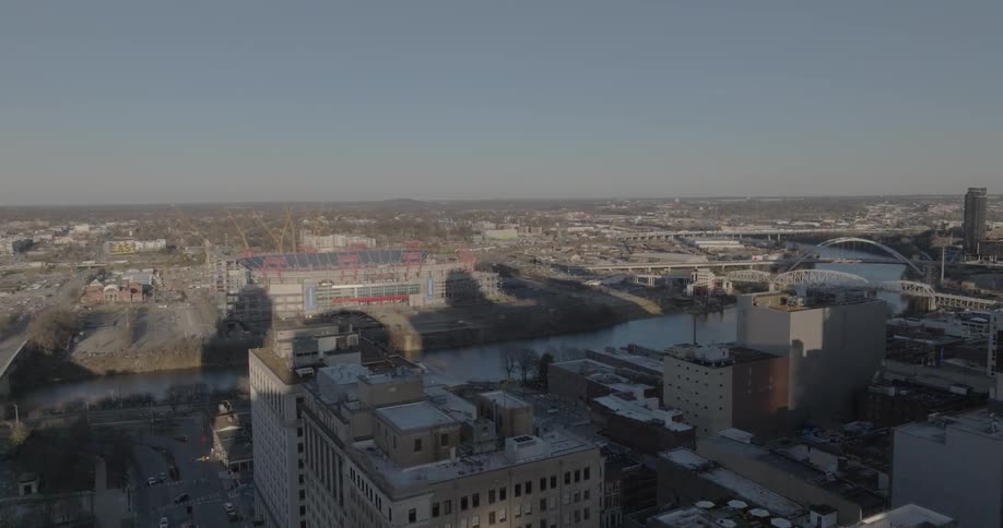 Aerial view shows stadium near the river with a bridge in the background