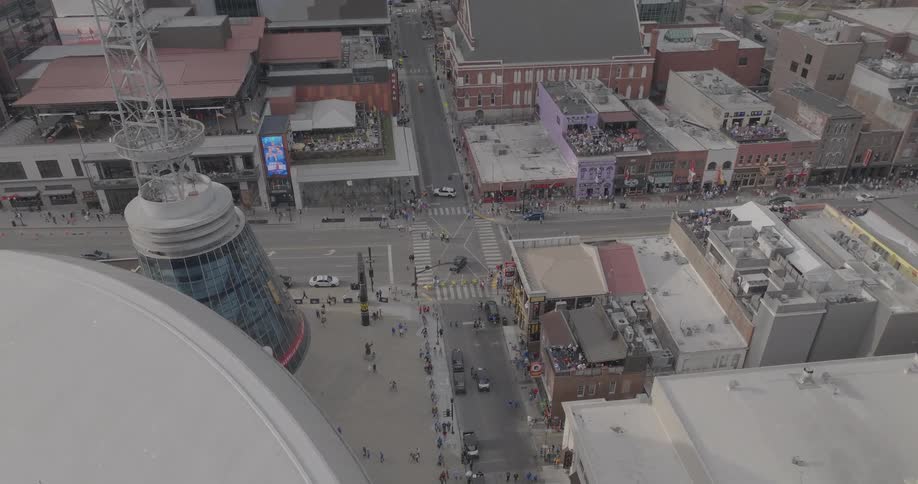 An aerial view of downtown nashville during the day shows crowds along broadway near the bridgestone arena and the ryman auditorium