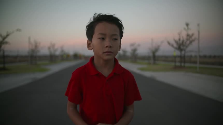 A young boy walks a quiet road alone