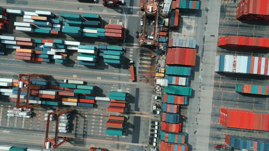 Aerial view of containers organized in a port terminal with cranes in operation